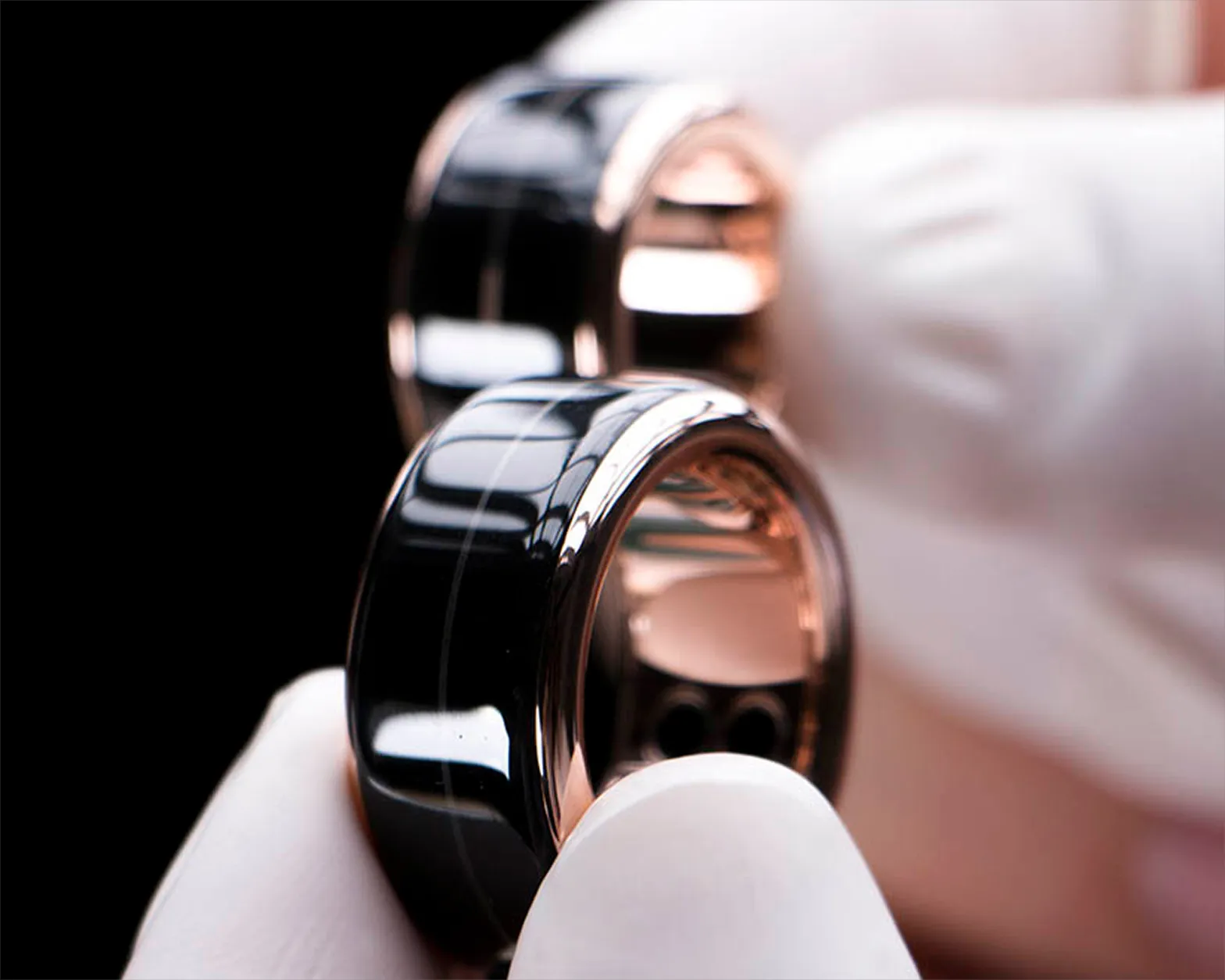 The HB Ring in solid 18K rosé gold, held in a gloved hand